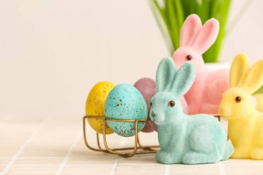 Sevimli Paskalya tavşanları ve masanın üzerinde yumurtaları olan tutucu, yakın plan.