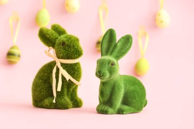 Pembe arka planda yeşil Paskalya tavşanları