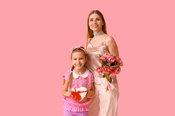 小女孩 她妈妈带着郁金香和粉色背景的礼物 — 图库照片
