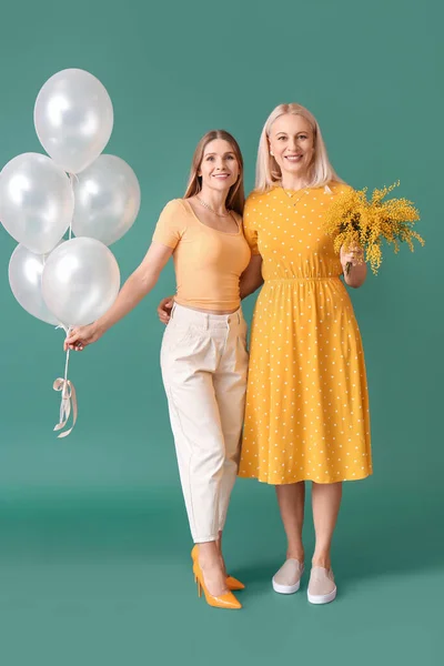 Young Woman Her Mother Flowers Balloons Green Background — Stock Photo, Image