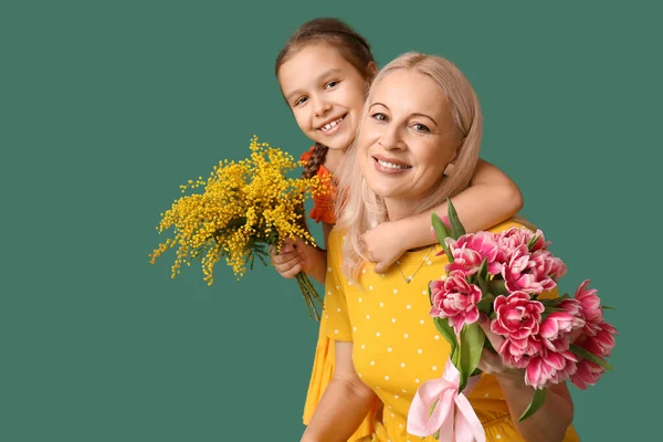 Kleines Mädchen Mit Großmutter Und Blumen Auf Grünem Hintergrund — Stockfoto