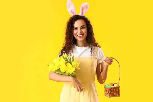 Jonge Afro Amerikaanse Vrouw Met Tulpen Paaseieren Mand Gele Achtergrond — Stockfoto