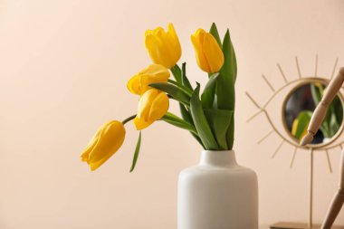 Renkli arkaplanda bir buket lale olan vazo