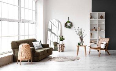 Koltuğu, koltuğu ve aydınlık duvarında Paskalya çelengi olan şık bir oturma odası.