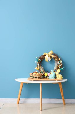 Paskalya yumurtaları, pasta ve renkli duvarın yanındaki masada güzel bir dekor.