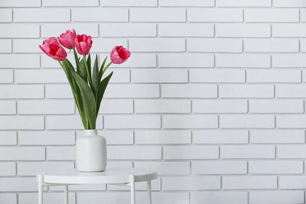 Vaas Met Mooie Tulpen Tafel Bij Witte Bakstenen Muur — Stockfoto