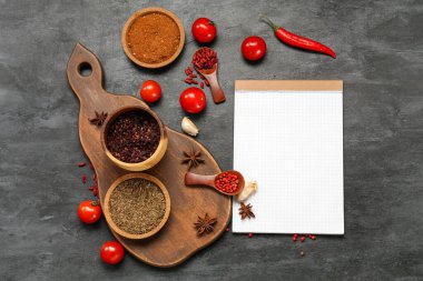 Baharat, sebze ve karanlık arka planda boş defter kompozisyonu