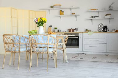 Mutfaktaki yemek masasında güzel kasımpatı çiçekleri olan vazo.