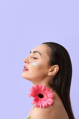 Yaratıcı makyajlı ve Gerbera çiçekli güzel bir kadın.