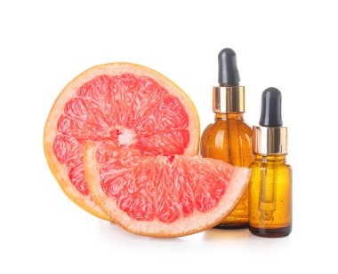 Beyaz arka planda gerekli yağ ve olgun greyfurt şişeleri