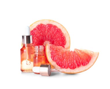 Beyaz zemin üzerinde gerekli yağ ve greyfurt parçaları şişeleri