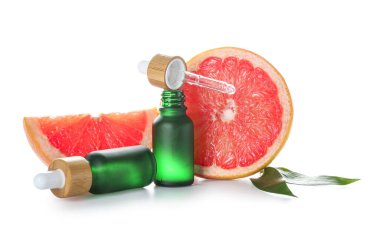 Beyaz zemin üzerinde greyfurt yağı şişeleri ile kompozisyon