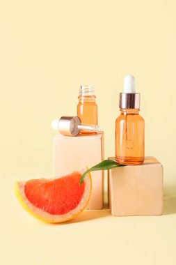 Renkli arka planda gerekli yağ, greyfurt dilimi ve dekoru içeren kompozisyon