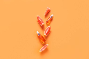 Renkli arka planda gerekli yağ ve greyfurt dilimlerinin bulunduğu kompozisyon