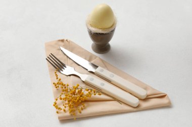 Beyaz arka planda mimoza çiçekleri olan Paskalya kutlaması için şık bir masa.