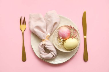 Pembe arka planda Paskalya kutlaması için şık masa ayarları