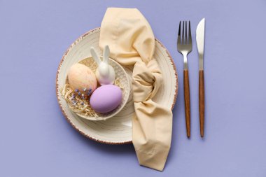 Mor arka planda Paskalya kutlaması için şık masa ayarları