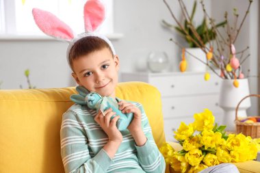 Evde tavşan kulaklı ve oyuncak tavşanlı şirin bir çocuk var. Paskalya kutlaması