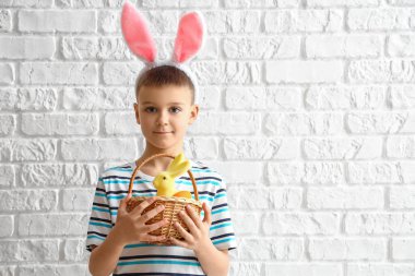 Tavşan kulaklı ve beyaz tuğlalı Paskalya sepetli şirin bir çocuk.