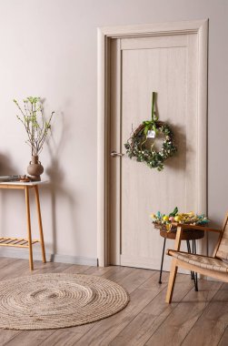 Paskalya çelengi ve tebrik kartı olan bir kapı.