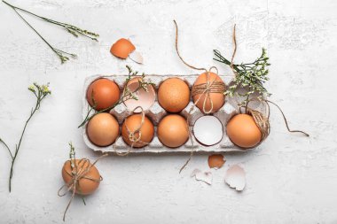 Paskalya yumurtaları, çiçekler ve hafif arka planda halatla tutucu