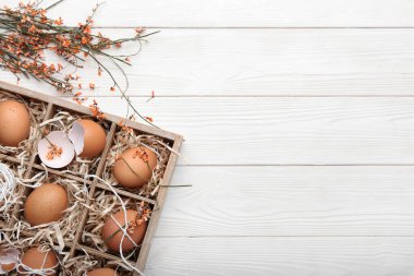 Paskalya yumurtaları ve çiçeklerle dolu bir kutu.