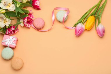 Uluslararası Kadınlar Günü kutlamaları için hediye edilen kompozisyon, renk arka planında çiçekler ve kurabiyeler
