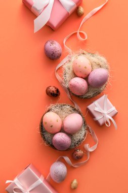Renkli arkaplanda güzel Paskalya yumurtaları ve hediyeleri olan kompozisyon