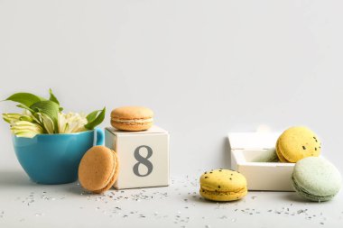 Beyaz arka planda tatlı badem kurabiyeleri ve çiçeklerle bezenmiş kompozisyon. Uluslararası Kadınlar Günü kutlamaları