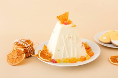 Geleneksel paskalya pastası, arkaplanda şekerli meyve ve kurutulmuş portakal dilimleri.