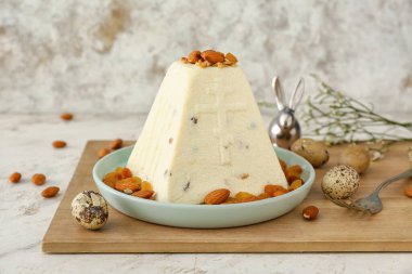 Lezzetli paskalya pastası bademli, kuru üzümlü ve açık arkaplanda yumurtalı.