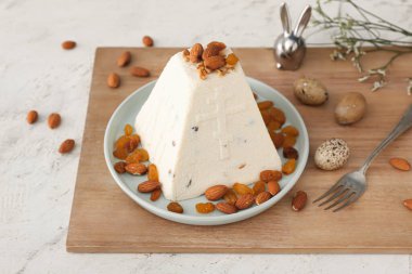 Lezzetli paskalya pastası bademli, kuru üzümlü ve açık arkaplanda yumurtalı.