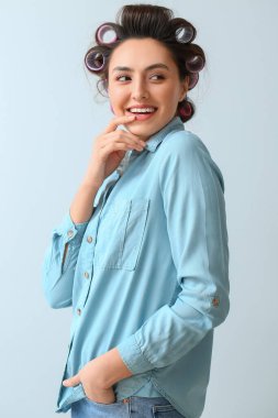 Açık arkaplanda saç lastikleri olan güzel genç bir kadın.