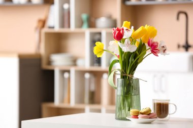 Güzel çiçekli vazo ve mutfaktaki yemek masasında lezzetli kahvaltı.