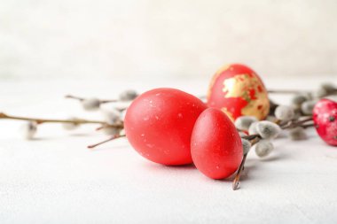 Painted Easter eggs and pussy willow branches on light background