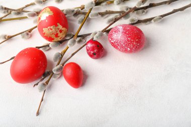 Painted Easter eggs and pussy willow branches on light background