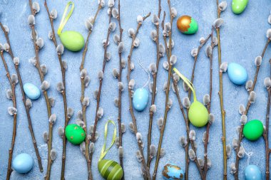 Painted Easter eggs and pussy willow branches on blue background