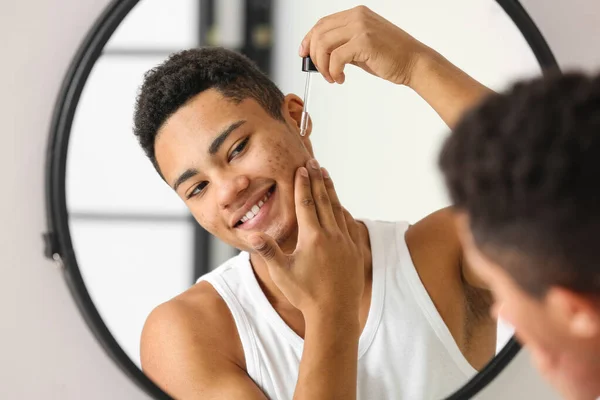 Young African American Guy Using Serum Skin Care Bathroom — Stock Photo, Image