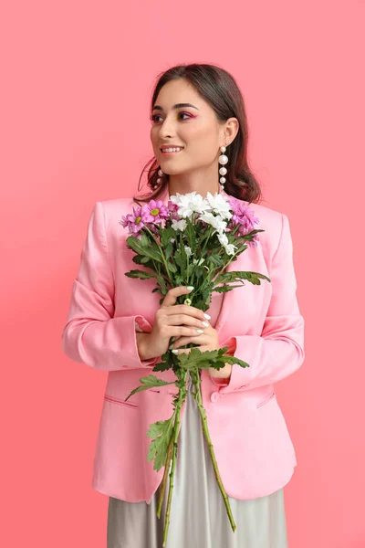 花の花束を保持し ピンクの背景を脇に見て創造的なメイクを持つ女性 国際女性デー — ストック写真