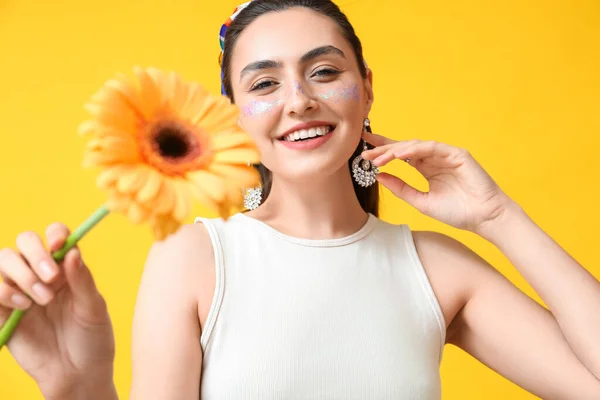 Yaratıcı Makyajı Takıları Olan Gülümseyen Kadın Sarı Arka Planda Gerbera — Stok fotoğraf