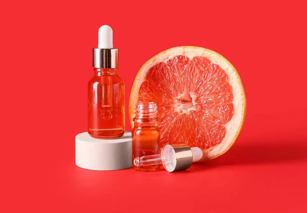Lahvičky Esenciálním Olejem Polovinou Grapefruitu Červeném Pozadí — Stock fotografie