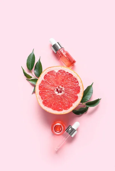 Склад Пляшками Ефірної Олії Листям Рослин Грейпфрутом Рожевому Фоні — стокове фото