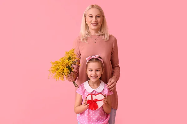 带着祖母和粉色背景的礼物的小女孩 国际妇女日 — 图库照片
