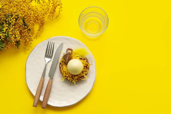 黄色の背景にミモザの花とイースターお祝いのためのスタイリッシュなテーブル設定 — ストック写真