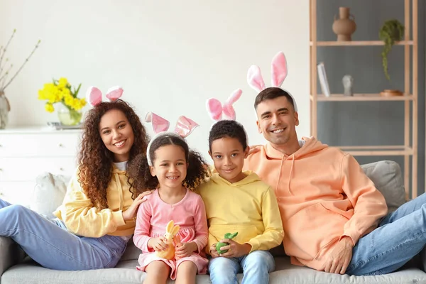 带着复活节兔子的小孩和他们的父母坐在家里的沙发上 — 图库照片