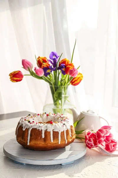 美味的复活节蛋糕和花瓶 桌上放着鲜花 — 图库照片