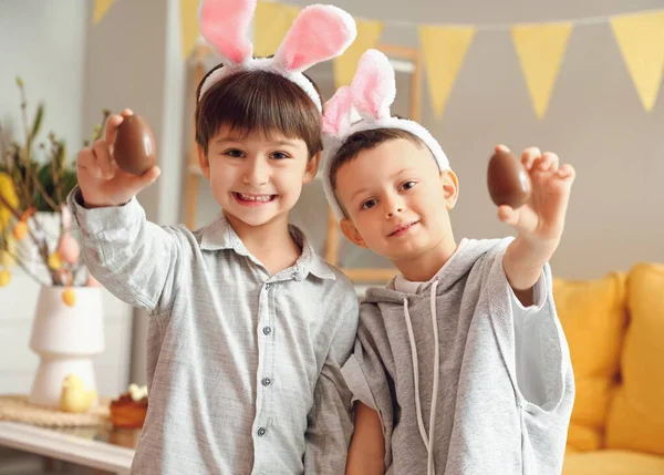 かわいいです男の子とともにウサギの耳とチョコレートイースターエッグホーム — ストック写真