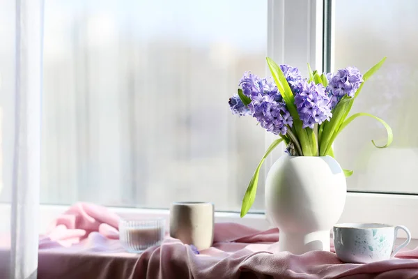 美しいヒヤシンスの花 窓辺の紅茶とキャンドルの花瓶 — ストック写真