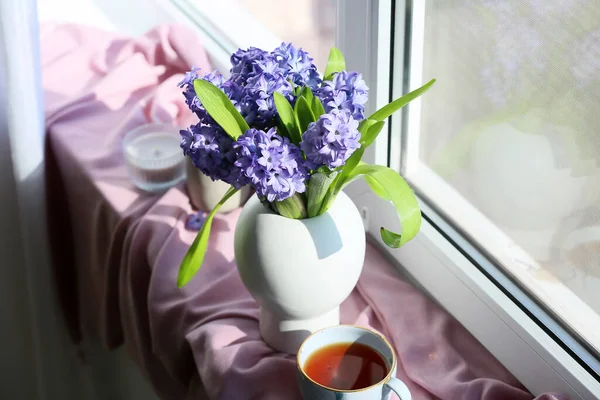 窓ガラスにはヒヤシンスとお茶のカップの花瓶 — ストック写真