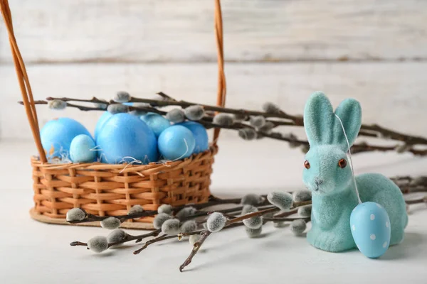 Weidenzweige Hase Und Korb Mit Bemalten Ostereiern Auf Hellem Holzgrund — Stockfoto